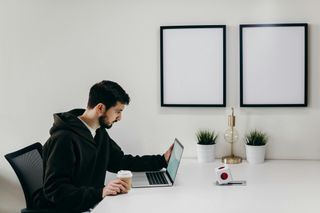 Man auditing accessibility of a website with a coffee